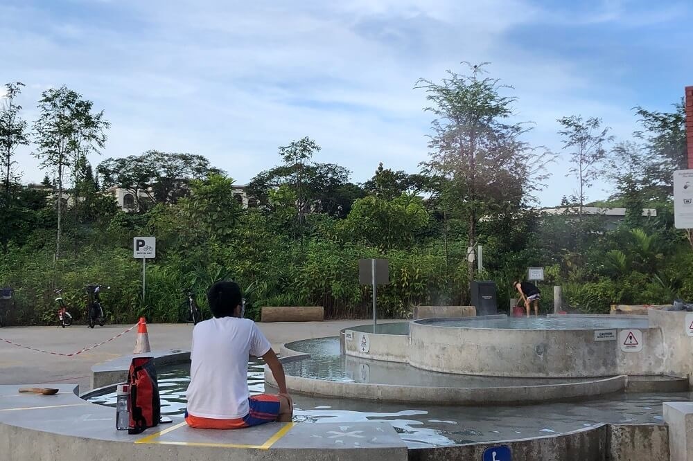 A man soaking his feet in the cascading pool at Sembawang Hot Spring Park